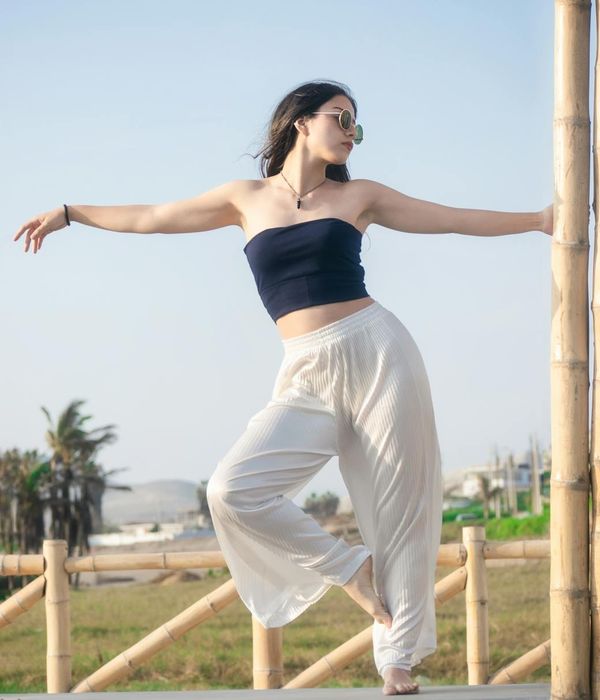 Woman in a graceful yoga pose with sky blue light accents.